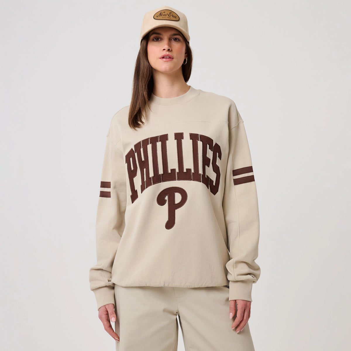 The model is wearing this MLB Arch Graphic Philadelphia Phillies Crew Neck Sweater in light beige. 4