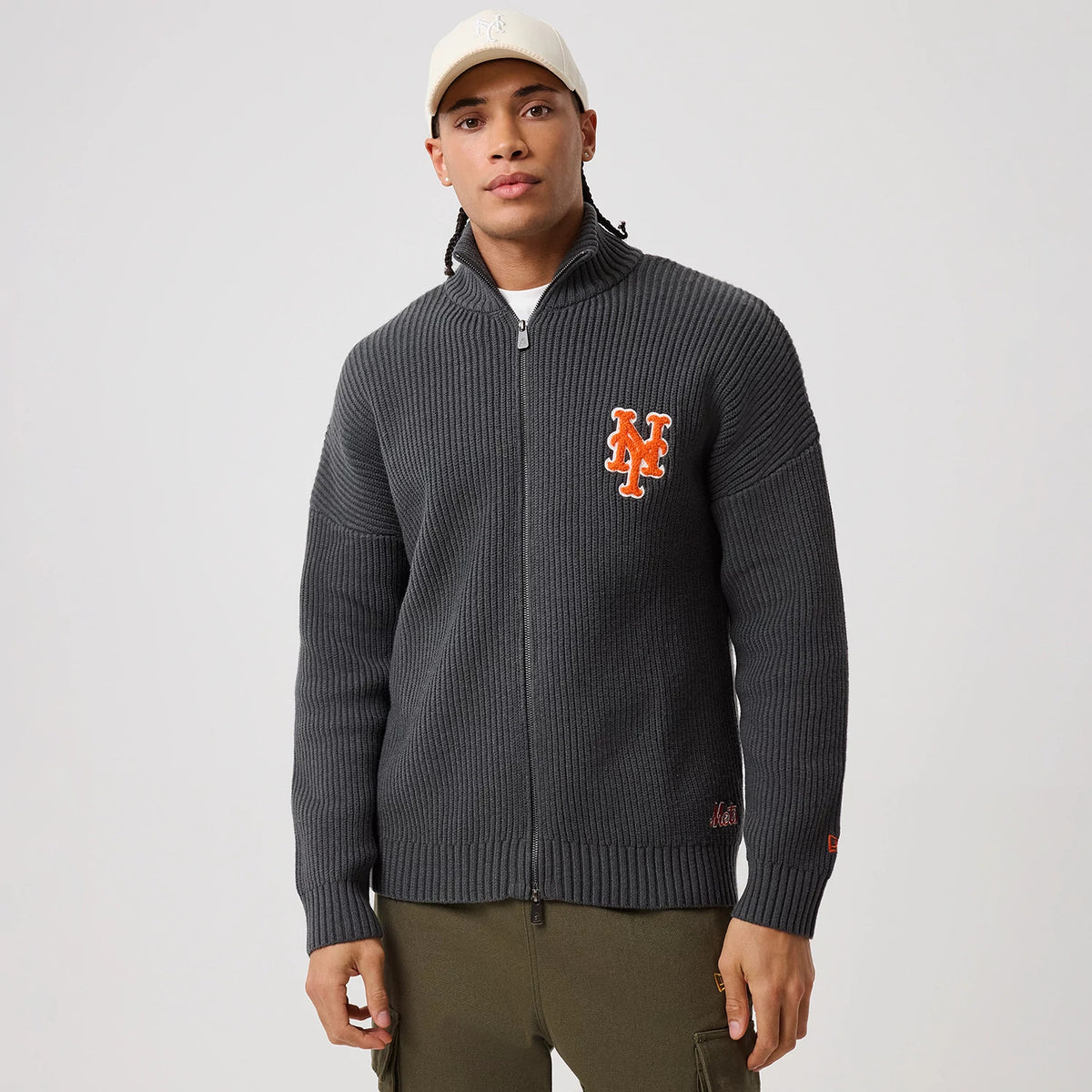 New Era New York Mets MLB Charcoal 2 Way Zip Cardigan, front view on a model featuring a large orange embroidered Mets logo on the left chest, a ribbed texture throughout, and a full-length zip closure.