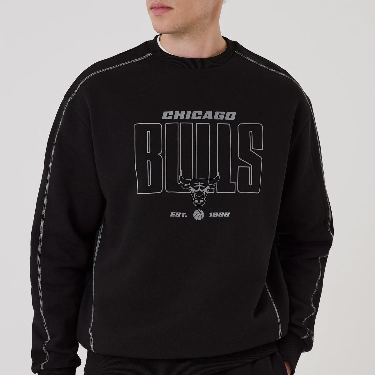 The model is wearing this NBA Graphic Chicago Bulls Crew Neck Sweater in black. 3