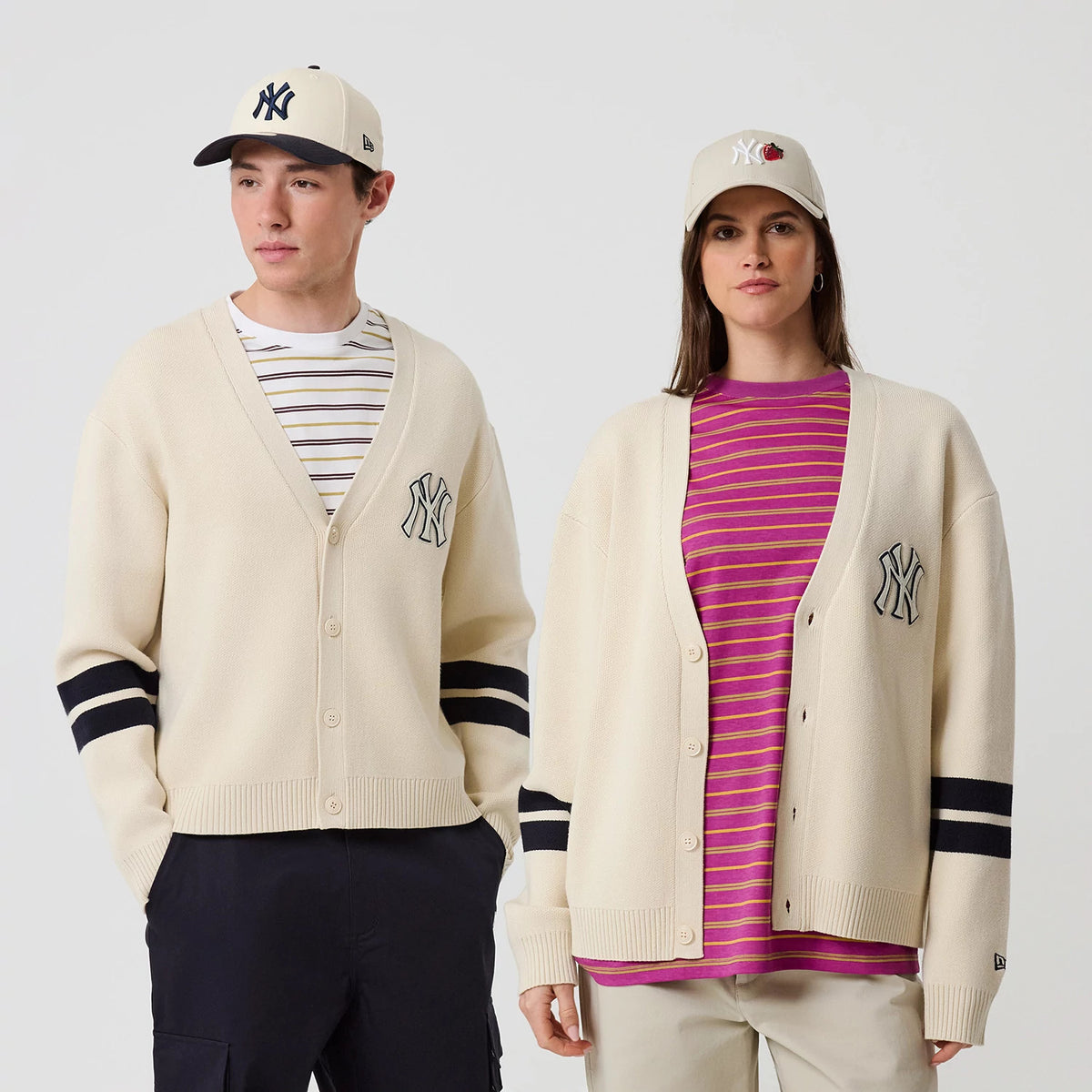 New Era New York Yankees MLB Knit Light Beige Cardigan, front view on a model with black stripes on arms, a large embroidered Yankees logo on the left chest, and cream-coloured buttons down the front, paired with a beige Yankees cap.