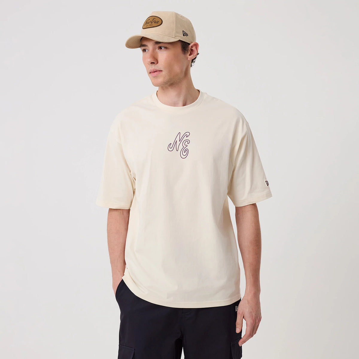 The model is wearing this New Era Crest Graphic Oversized T-Shirt in open white. 3