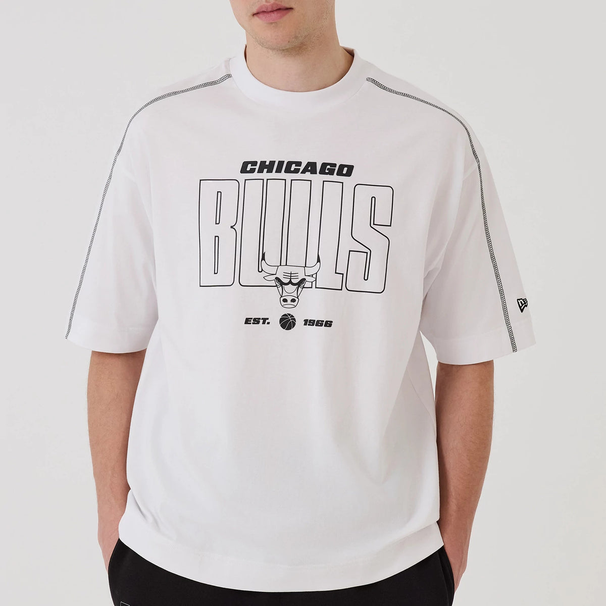 New Era Chicago Bulls NBA Graphic White Boxy T-Shirt, front view featuring Chicago Bulls lettering and a bull graphic on the chest, with Est. 1966 text below, and an embroidered New Era logo on the left sleeve near the edge of the short sleeve.