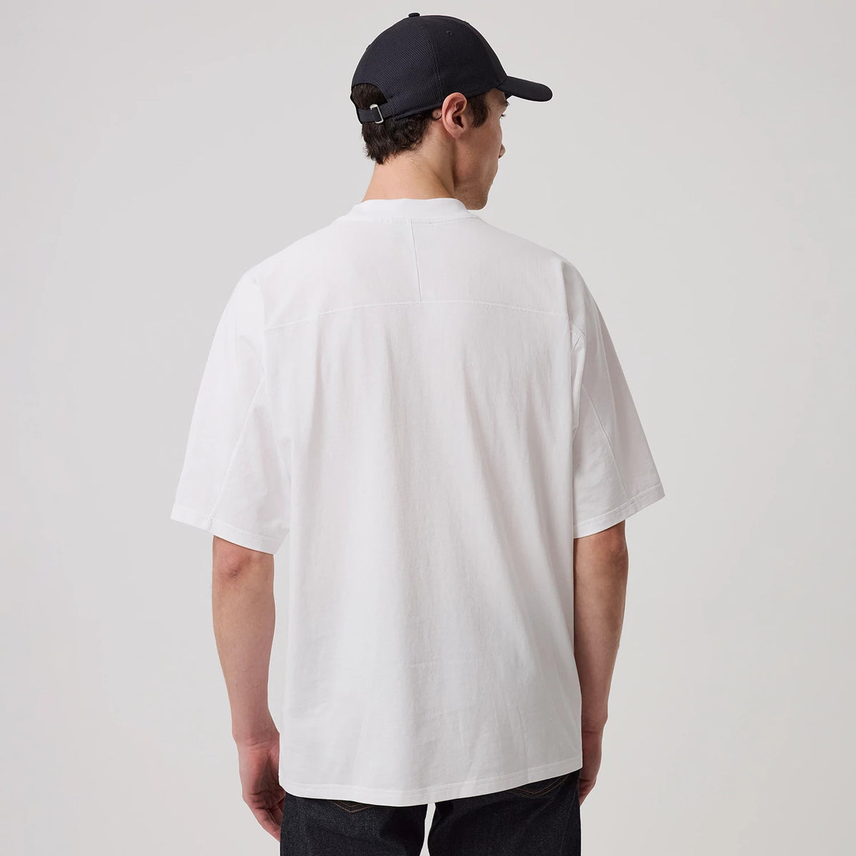 New Era New York Yankees MLB Arch Graphic White Oversized T-Shirt, back view on a model with a dark cap, showing the plain white back, relaxed fit design and short sleeves, with no graphics or logos on the rear side.