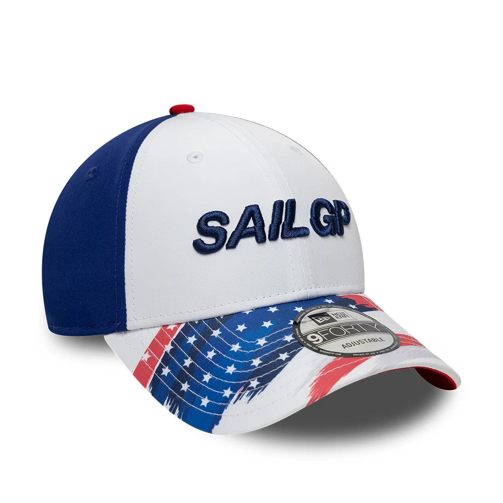 Sail GP USA Air Event White New Era 9FORTY Adjustable Cap, three-quarter view showing the raised blue Sail GP embroidery on the white front panels, an American flag pattern on the curved visor, and a 9FORTY size sticker on the top.