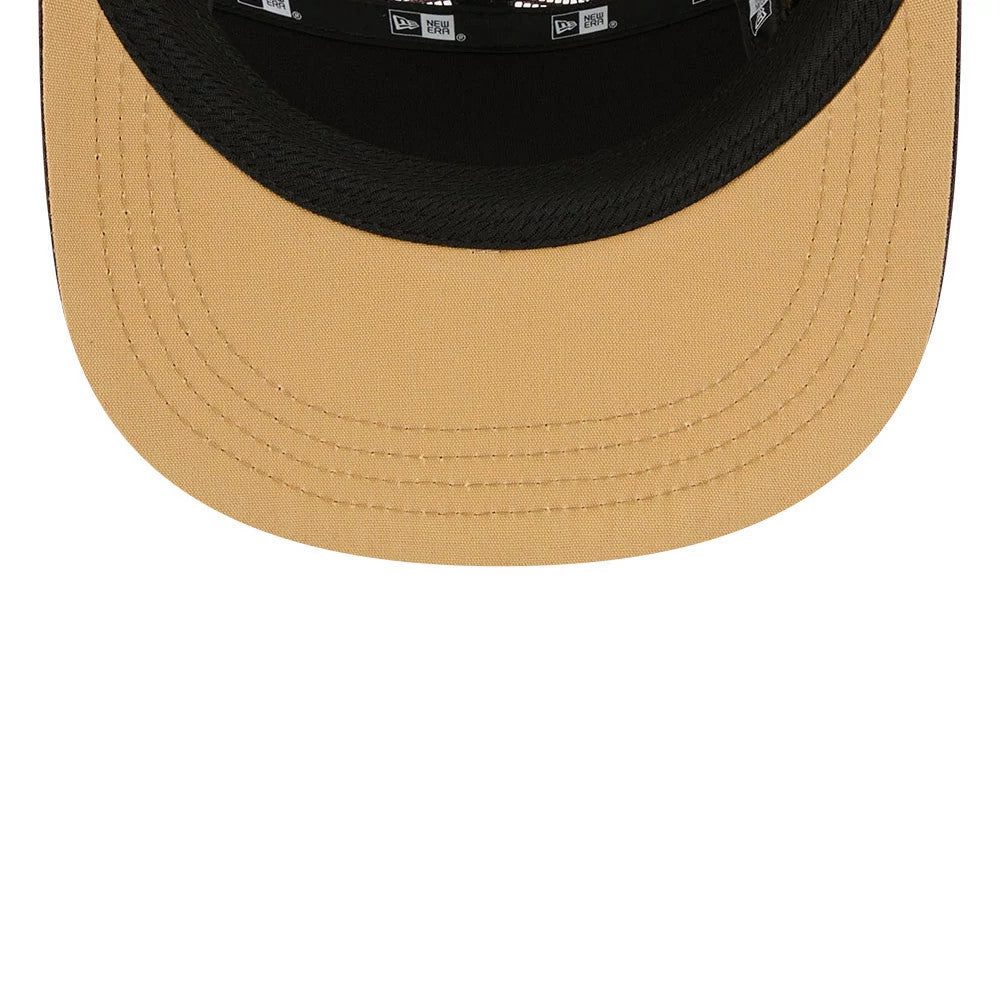 New Era Elevated Basics Woodland Camo Camper Cap, inside view showing the beige underside of the visor, black sweatband with New Era branding, and black taping along the interior seams.