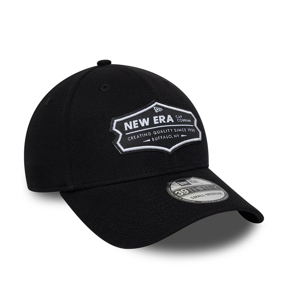 New Era Jersey Black 39THIRTY Stretch Fit Cap, three-quarter view showing a large white outlined patch with New Era branding on the front panel, a curved black visor, and a 39THIRTY size sticker on the top of the visor.