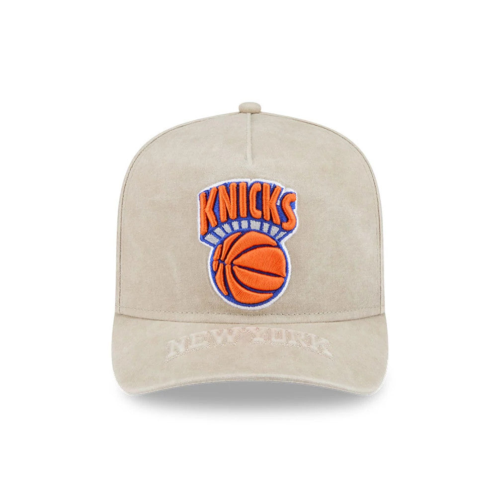 New York Knicks NBA Light Beige New Era 9FIFTY A-Frame Snapback Adjustable Cap, front view showing the raised orange and blue Knicks logo embroidered on the centre of the structured crown and the New York text embroidered on the light beige visor.
