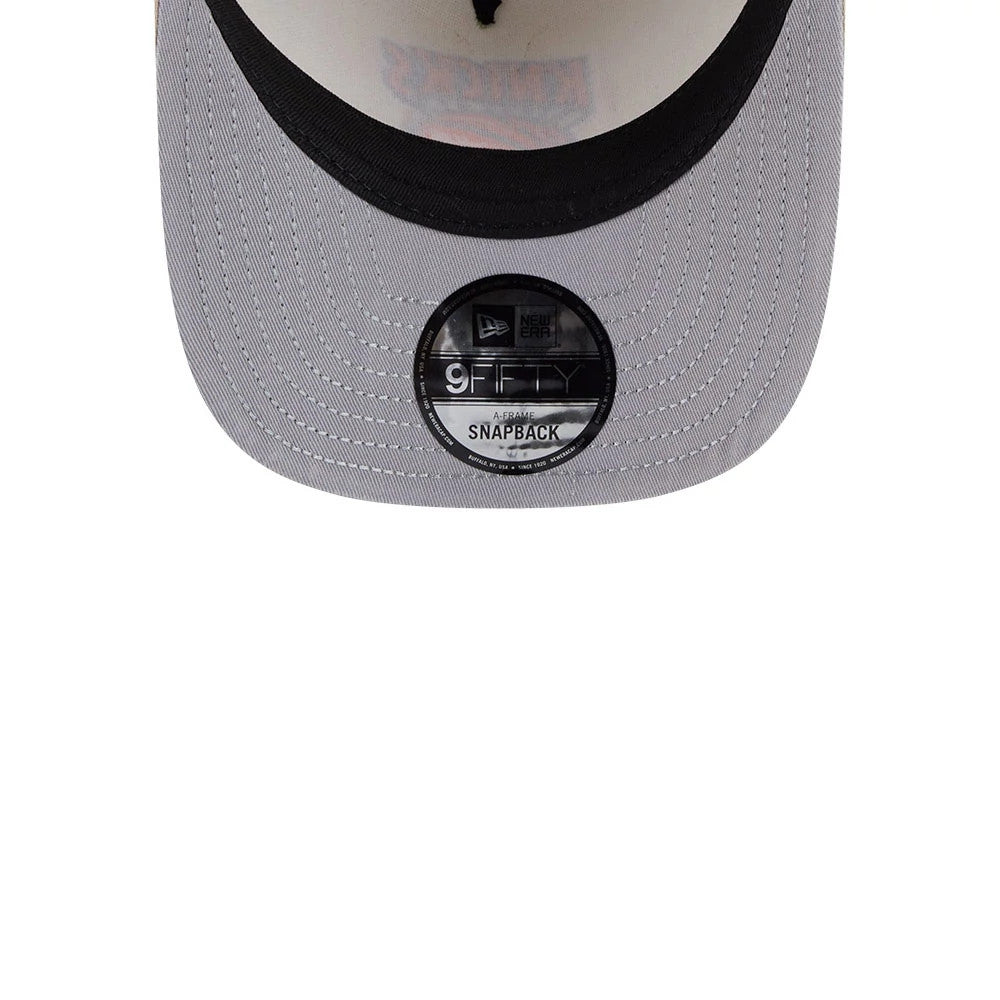 New York Knicks NBA Light Beige New Era 9FIFTY A-Frame Snapback Adjustable Cap, top view showing a black visor with a grey undervisor, featuring a distinctive 9FIFTY size sticker and intricate stitching around the edge.