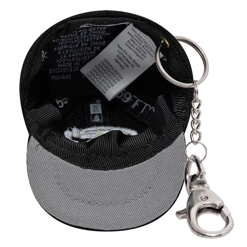 Gettomasa X New Era Black Key Chain, inside view showing the grey undervisor, black sweatband, New Era labels, and attached silver keyring and clasp chain emerging from the eyelet of the mini cap design.