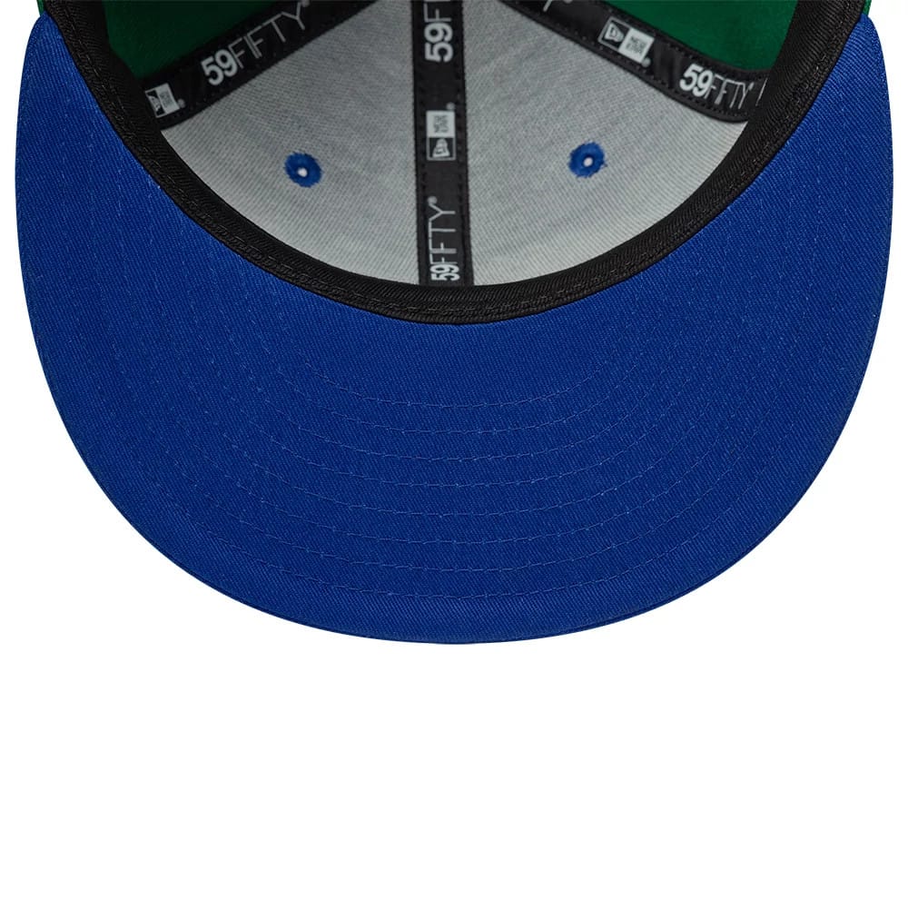Dallas Mavericks NBA Hardwood Classic Players Blue New Era 59FIFTY Fitted Cap, inside view showing a green undervisor, grey sweatband, and black taping with repeated 59FIFTY branding, along with blue embroidered eyelets on the crown.