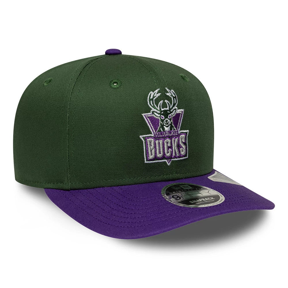 Bucks NBA Hardwood Classic Dark Green New Era 9FIFTY Snapback Adjustable Cap, three-quarter view showing the retro Bucks logo with purple embroidery on the front panel, a contrasting purple visor, and the 9FIFTY size sticker on the top.