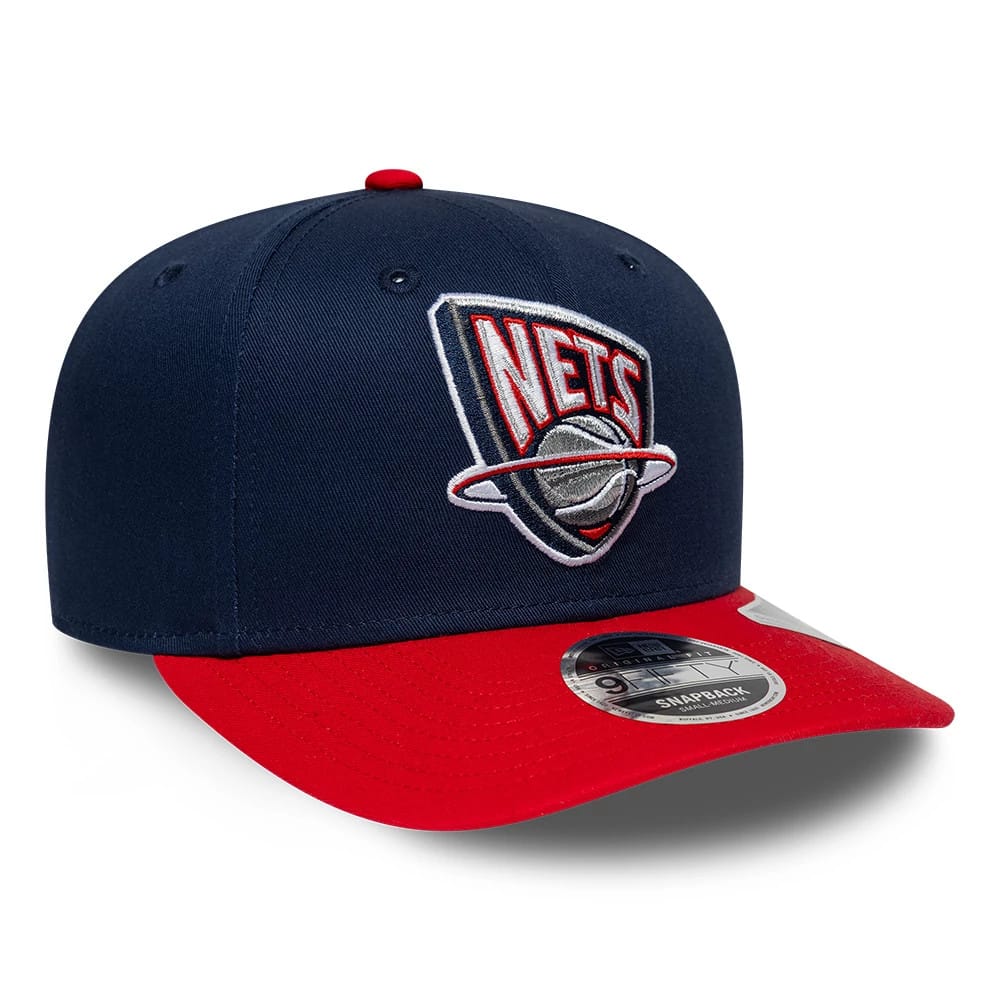 Nets NBA Hardwood Classic Dark Blue New Era 9FIFTY Snapback Adjustable Cap, front view showing the raised embroidered Nets logo in red and grey on the front panel, with a contrasting red visor and the 9FIFTY size sticker on the top.