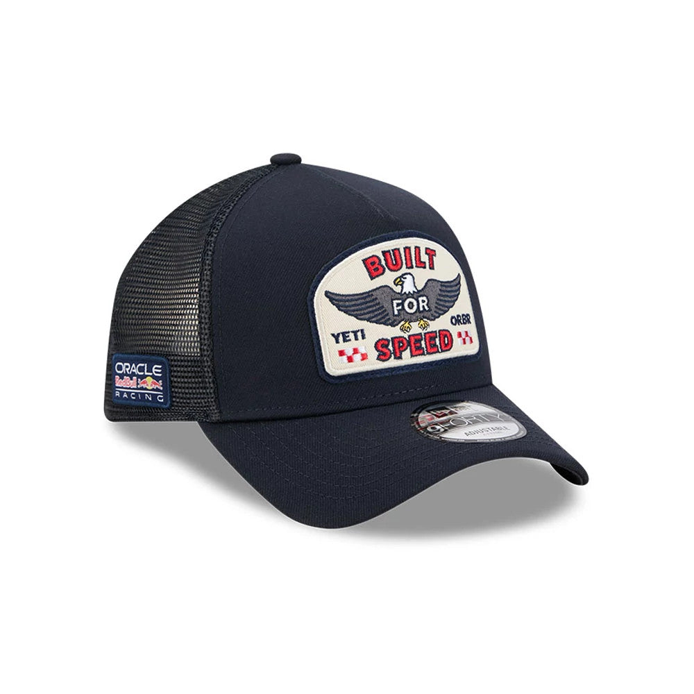 Red Bull Racing Yeti X Red Bull Racing Black New Era 9FORTY A-Frame Trucker Adjustable Cap, three-quarter view showing the large embroidered patch with a winged eagle and 'Built for Speed' text on the front panel, with a curved black visor.