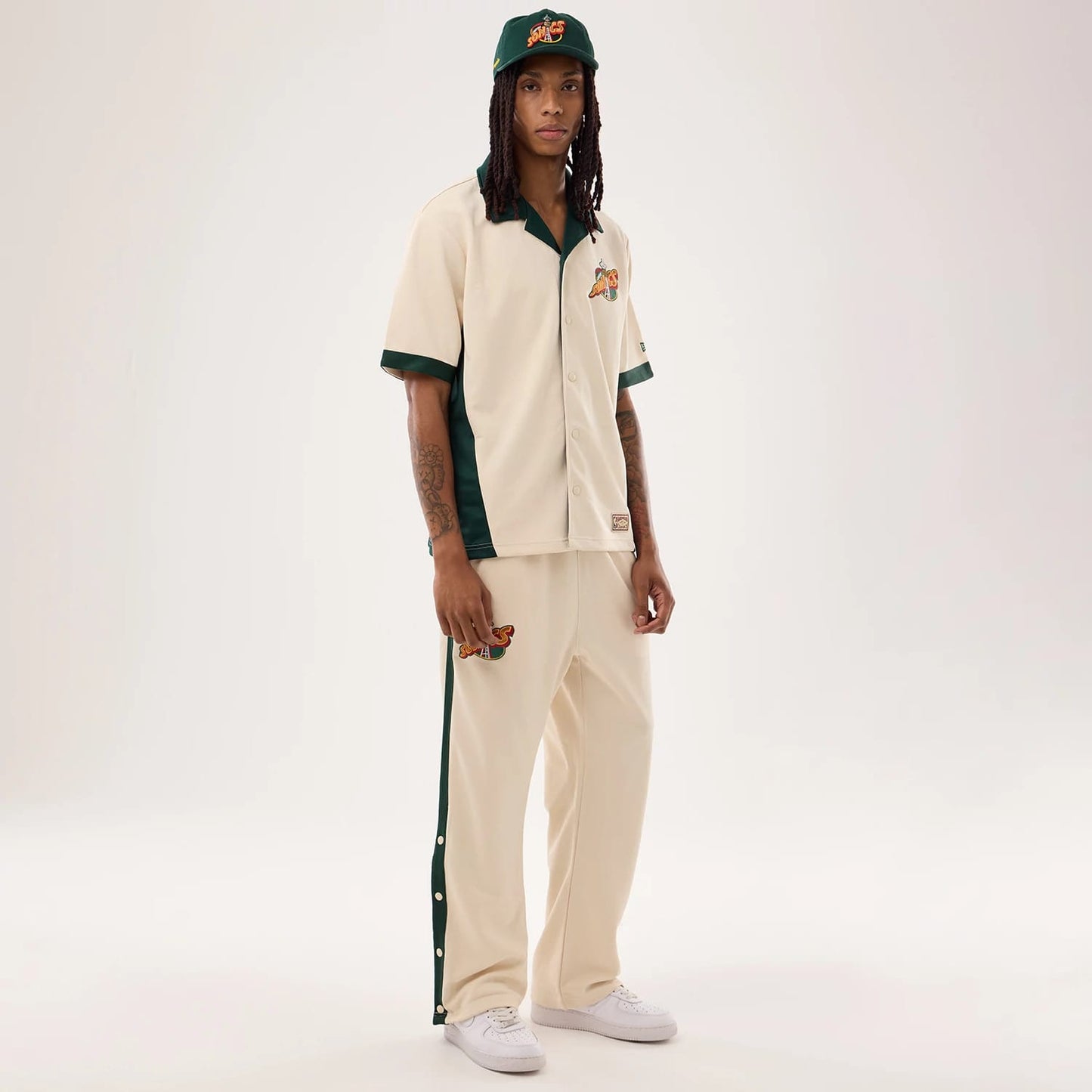 The model is wearing this NBA Hardwood Classic Revere Seattle Supersonics Short Sleeve Shirt in light beige. 8
