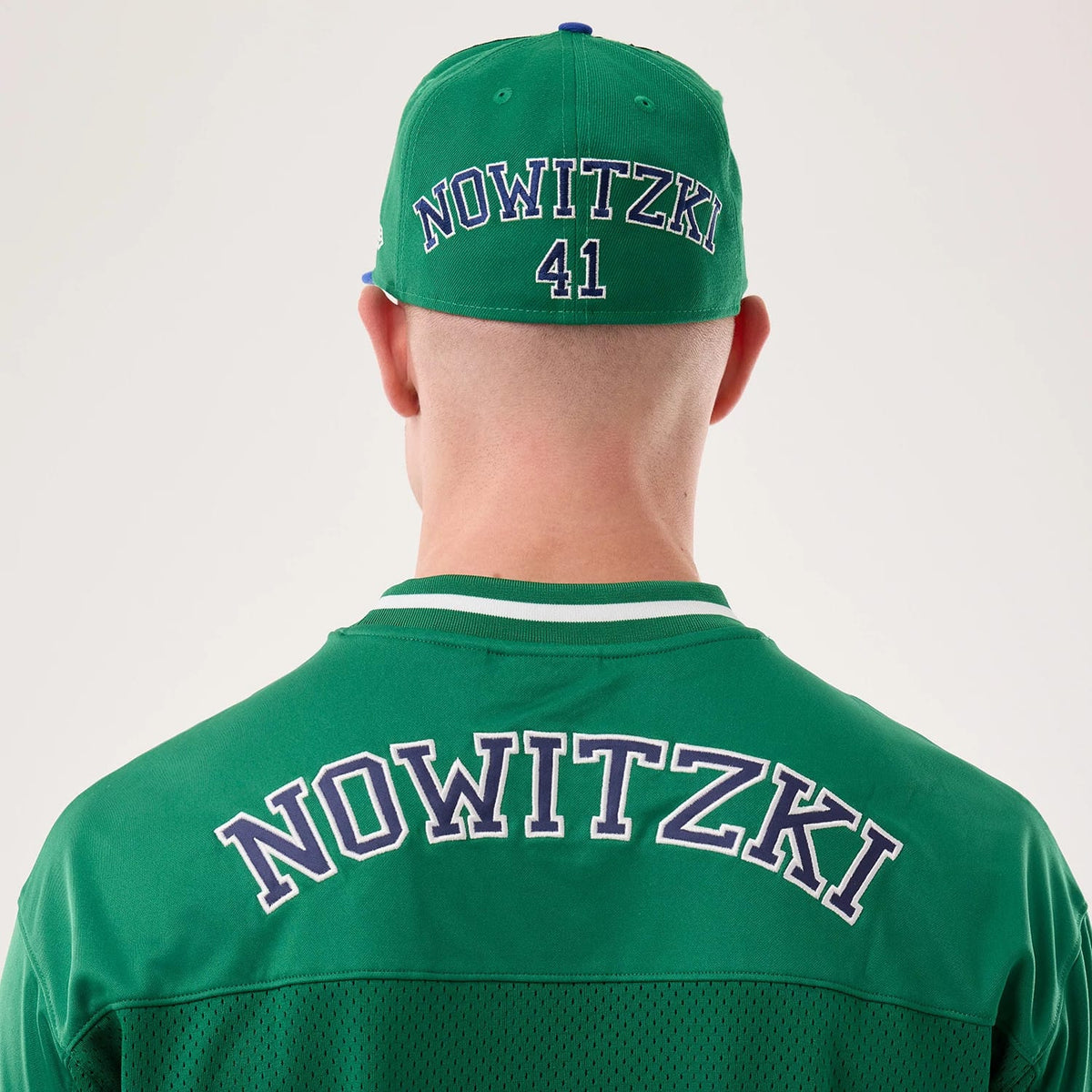 New Era Dallas Mavericks NBA Hardwood Classic Mesh Oversized Green T-Shirt, back view on a model with a matching cap, showing Nowitzki lettering across the shoulders, a soft white collar trim, and 41 embroidered on the back of the green cap.