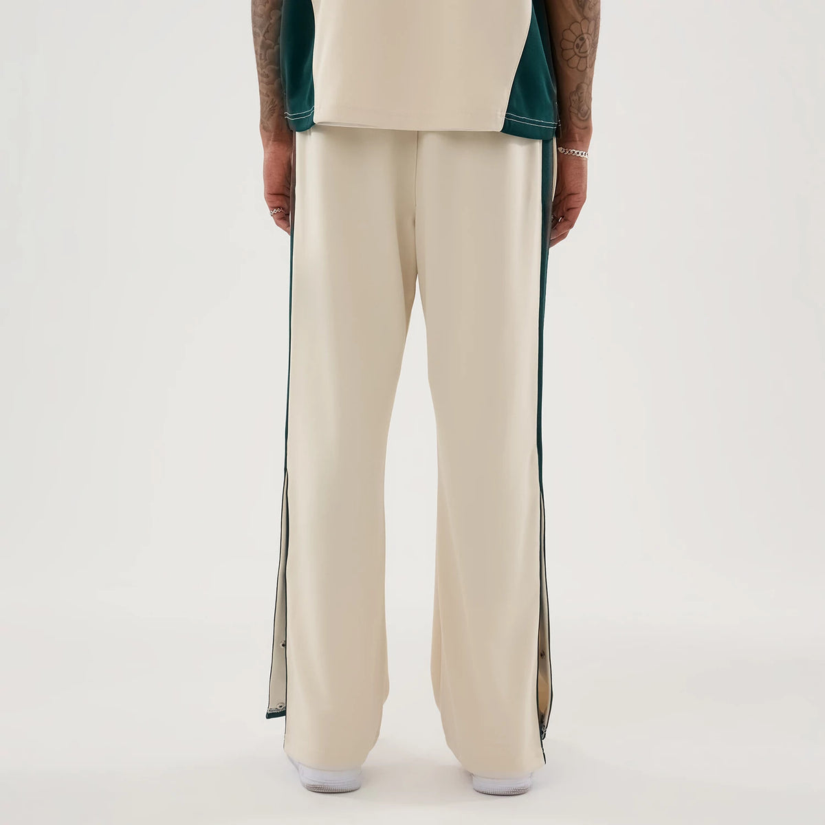 New Era Supersonics NBA Hardwood Classic Beige Straight Leg Joggers, back view on a model with side snap buttons on the dark green stripe running down the sides, tailored fit through the legs, and light beige fabric.