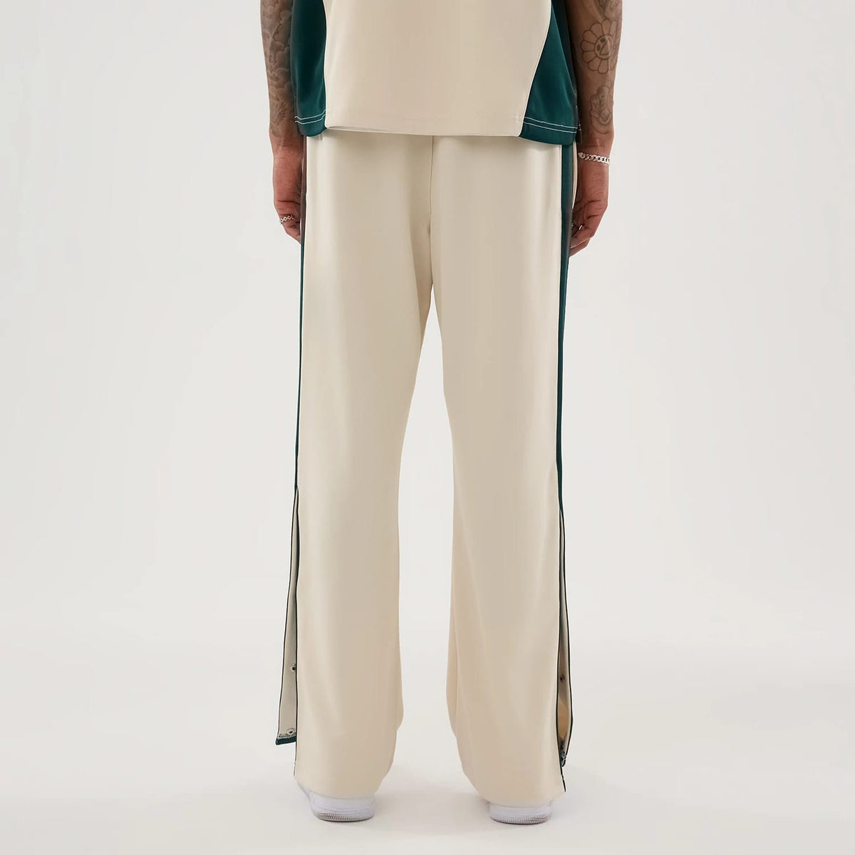 New Era Supersonics NBA Hardwood Classic Beige Straight Leg Joggers, back view on a model with side snap buttons on the dark green stripe running down the sides, tailored fit through the legs, and light beige fabric.