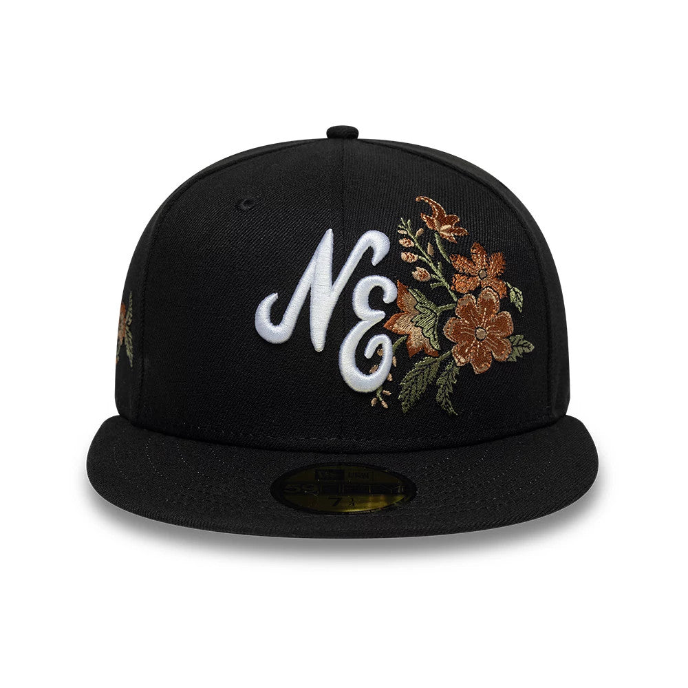 New Era Floral Black 59FIFTY Fitted Cap, front view showing an intricately embroidered white NE logo with detailed floral designs in brown and green on the front panels, complemented by a structured black flat visor and gold 59FIFTY size sticker.