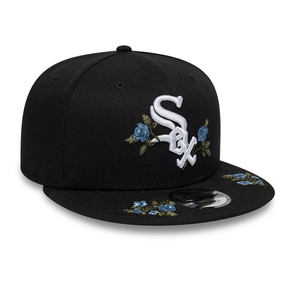 Chicago White Sox MLB Floral Black New Era 9FIFTY Snapback Adjustable Cap, front view showing the raised white Sox embroidery with blue floral accents on the front panels and visor, complete with a 9FIFTY size sticker on the flat black visor.