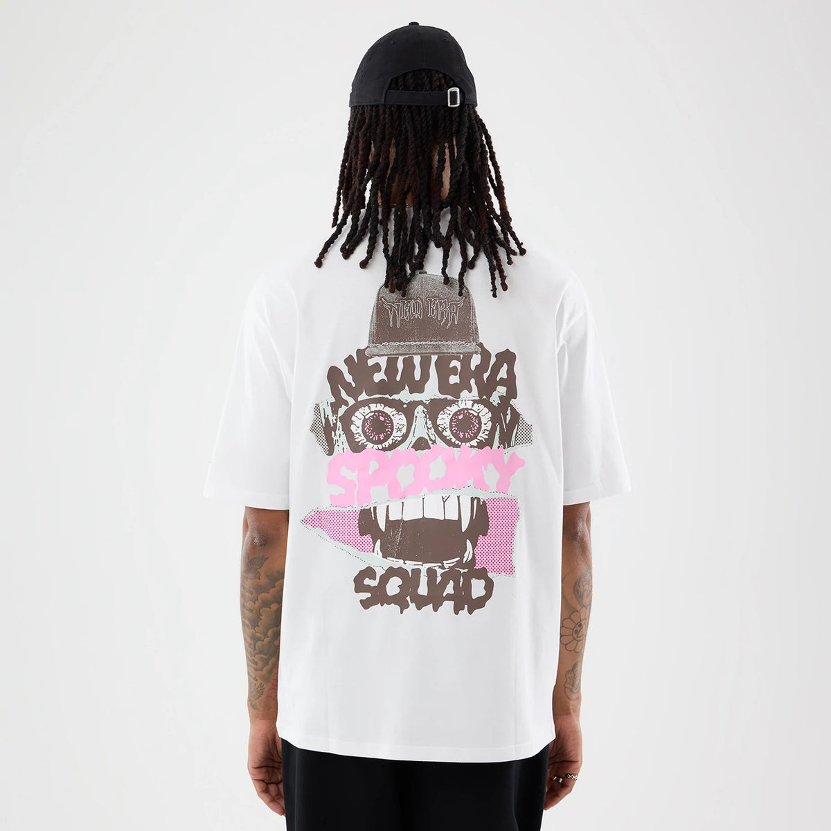 New Era Spooky Graphic Oversized White T-Shirt, back view on a model showing a graphic design with a skull featuring large eyes, pink and brown Spooky and Squad text, and a small New Era logo on top of the skull.