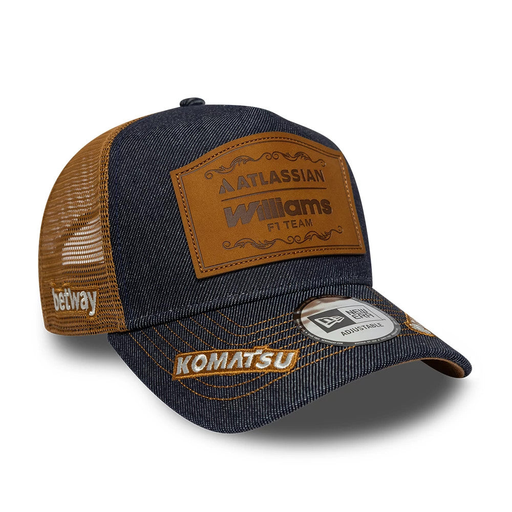 Williams Carlos Sainz Austin Race Special Navy New Era 9FORTY E-Frame Trucker Adjustable Cap, three-quarter view showing a brown Atlassian Williams badge on the navy front panel, brown mesh back panels.