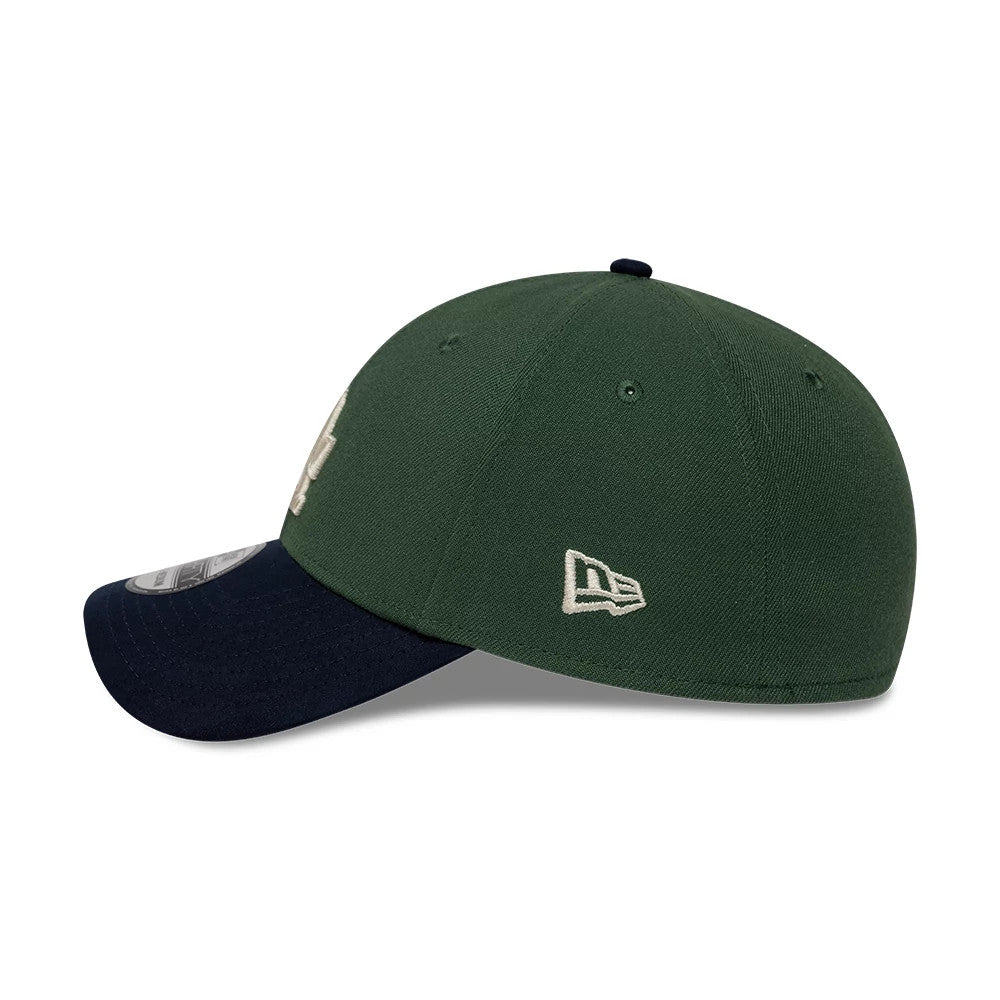 LA Dodgers MLB Faux Suede Dark Green & Navy New Era 39THIRTY Stretch Fit Cap, side view showing the embroidered New Era flag logo on the dark green crown, a navy curved visor with a 39THIRTY size sticker, and a slightly structured profile.