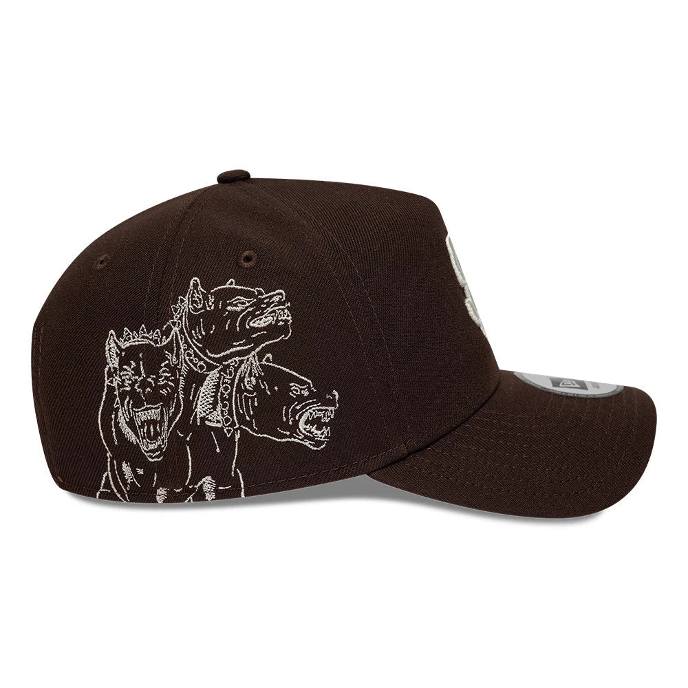 Padres MLB Mythical Icon Dark Brown New Era 9FORTY E-Frame Adjustable Cap, side view showing a fierce white embroidered Cerberus graphic on the right side panel, with a pre-curved visor and a 9FORTY size sticker on the brown crown.