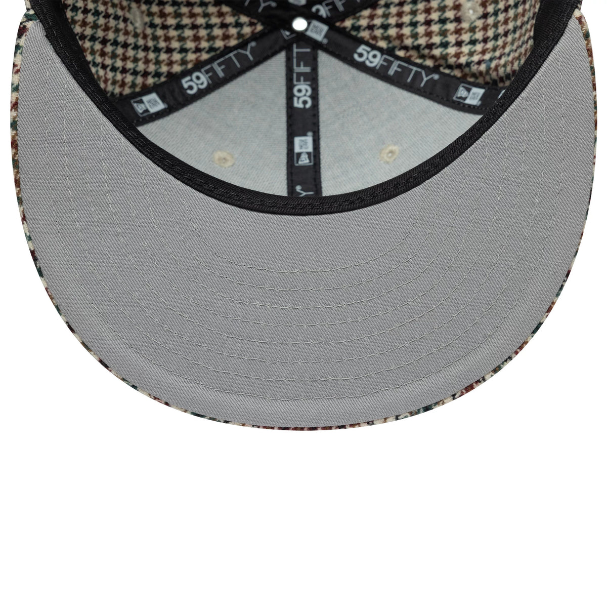 Kesi x New Era Multi 59FIFTY Fitted Cap, inside view showing the grey undervisor, houndstooth-patterned lining on the inside of the crown, and branded black taping with 59FIFTY logos running across the panels.