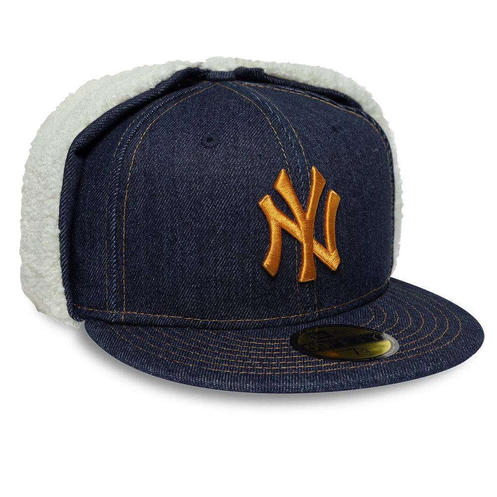 New York Yankees MLB Denim Navy Dogear New Era 59FIFTY Fitted Cap, three-quarter view showing a gold embroidered NY logo on the structured denim crown, navy flat visor with stitching, and cream dogear flaps, with a gold 59FIFTY size sticker.