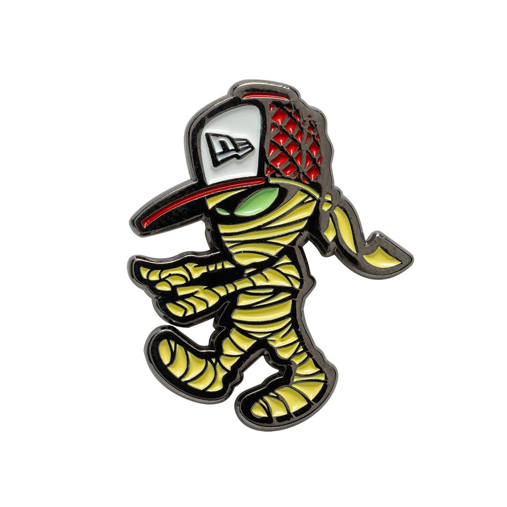 New Era Halloween Mummy Grey Pin Badge, front view showing a cartoon mummy character with green eyes and a wrapped body, wearing a red and grey cap featuring an embroidered New Era logo on the front panels.