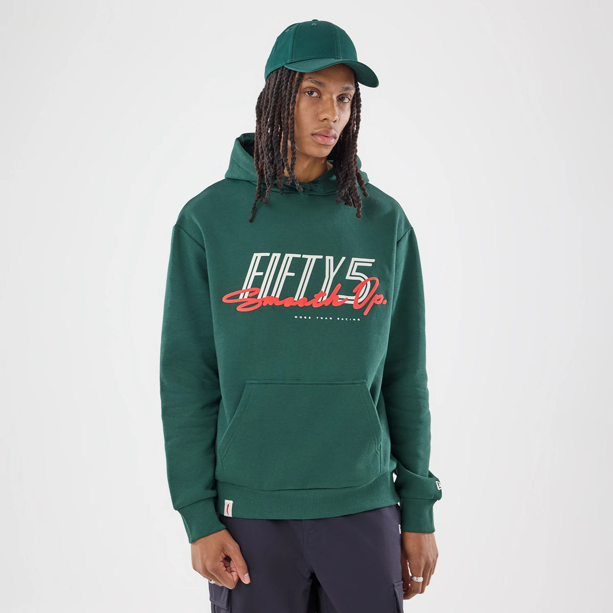 The model is wearing this Carlos Sainz Team Fifty5 Smooth Oversized Pullover Hoodie in dark green. 1