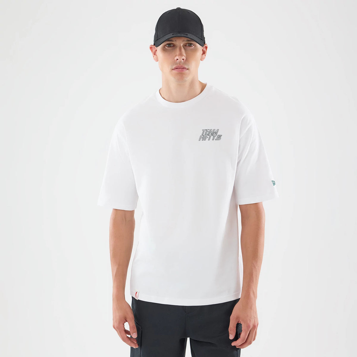 New Era Carlos Sainz Team Fifty5 Mexico White Oversized T-Shirt, front view on a model featuring a small printed Team Fifty5 logo on the left chest, a New Era logo on the left sleeve, and plain white oversized design.
