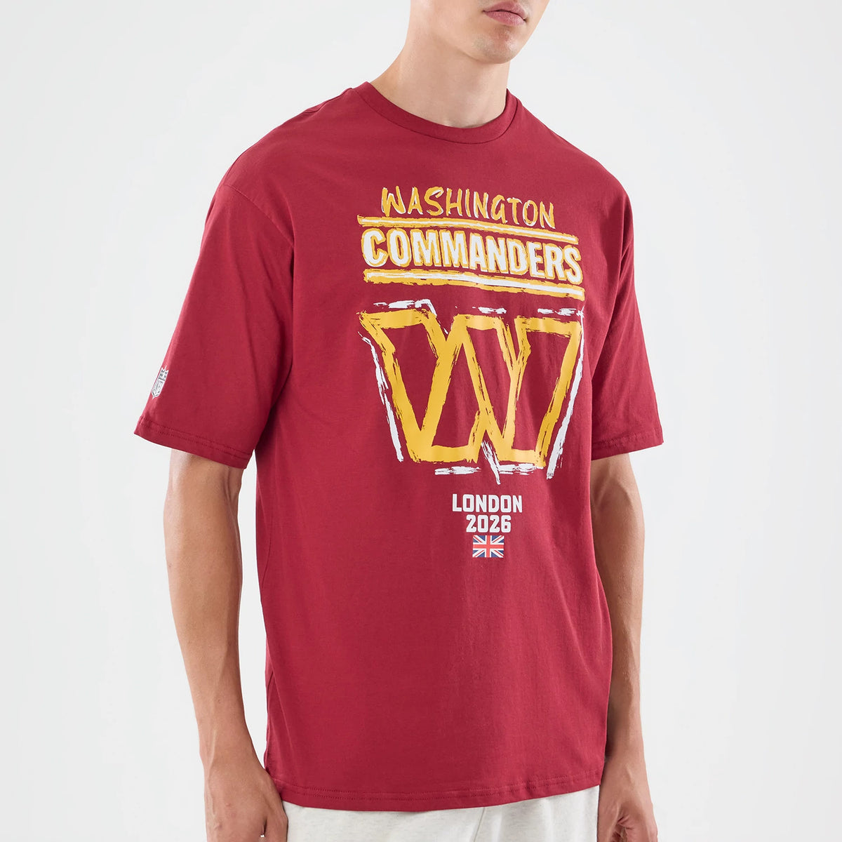 New Era Washington Commanders NFL Graphic Slogan Dark Red Oversized T-Shirt, three-quarter view featuring a model wearing the t-shirt with large yellow and white printed W logo on the chest, Washington Commanders lettering above.