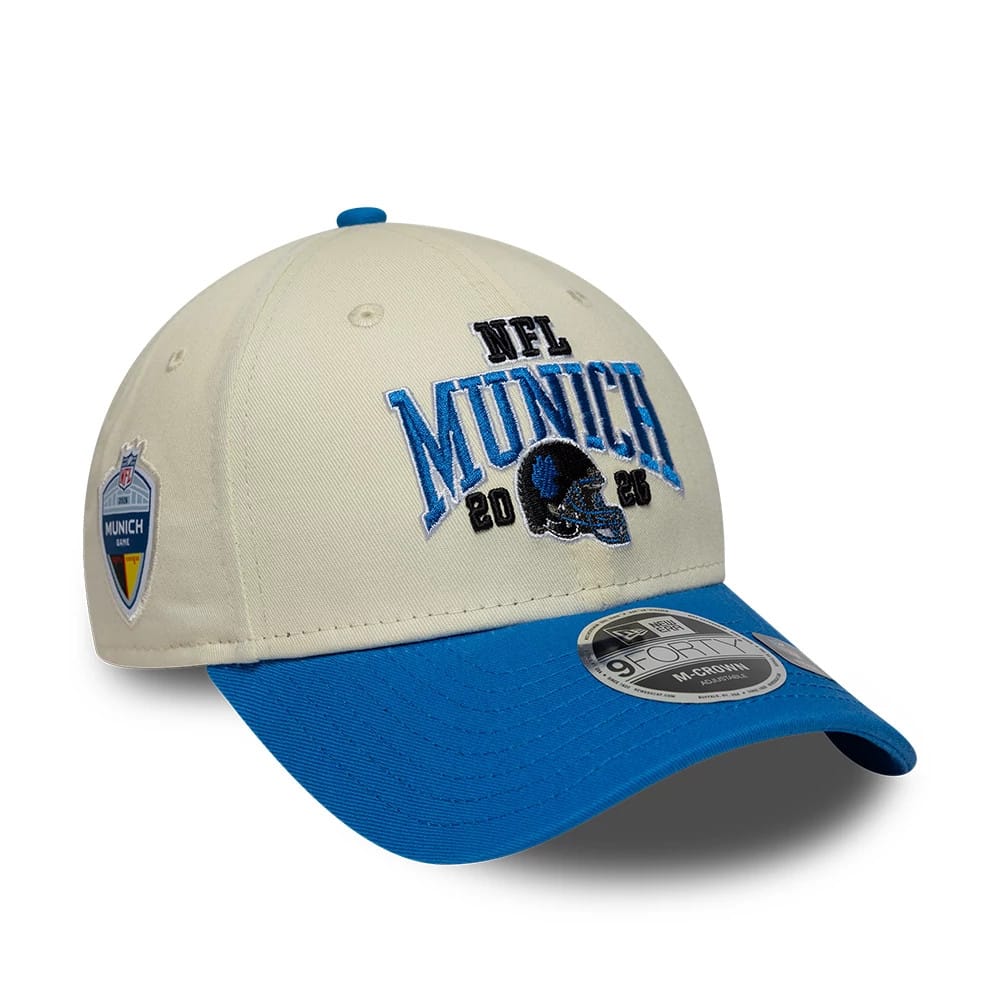 Lions NFL International Games 2026 Munich White & Blue New Era 9FORTY M-Crown Adjustable Cap, front view showing contrasting blue visor with a 9FORTY size sticker, NFL Munich 2026 text and logo on the structured white crown, and side patch.