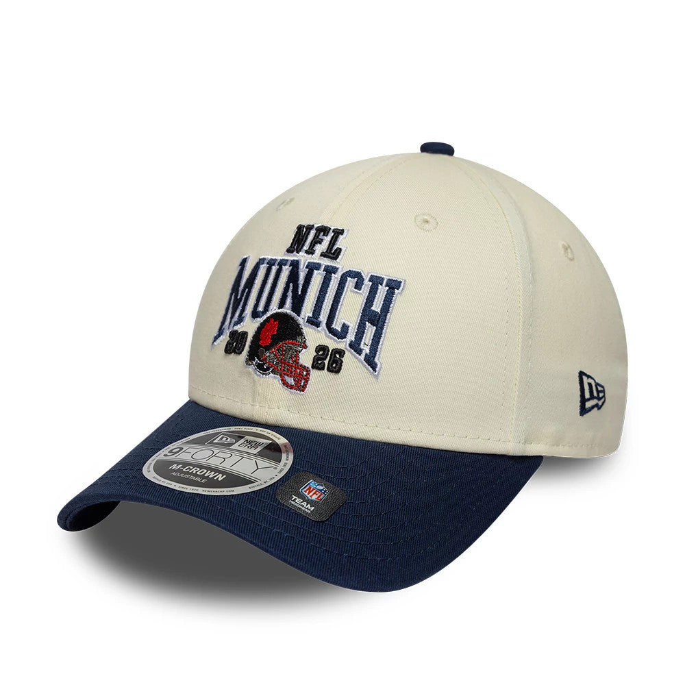 Patriots NFL International Games 2026 Munich White & Dark Blue New Era 9FORTY M-Crown Adjustable Cap, front view showing raised embroidered NFL Munich 2026 logo on the structured white crown, dark blue visor with 9FORTY size sticker.