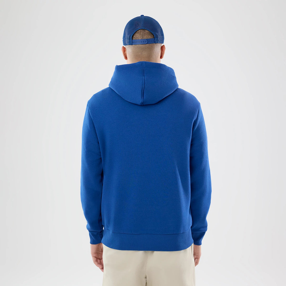 New Era Indianapolis Colts NFL International Games 2026 Blue Pullover Hoodie, back view on a model with a matching cap, showcasing the solid blue colour of the hoodie, a prominent hood, and ribbed cuffs and hem for a structured finish.