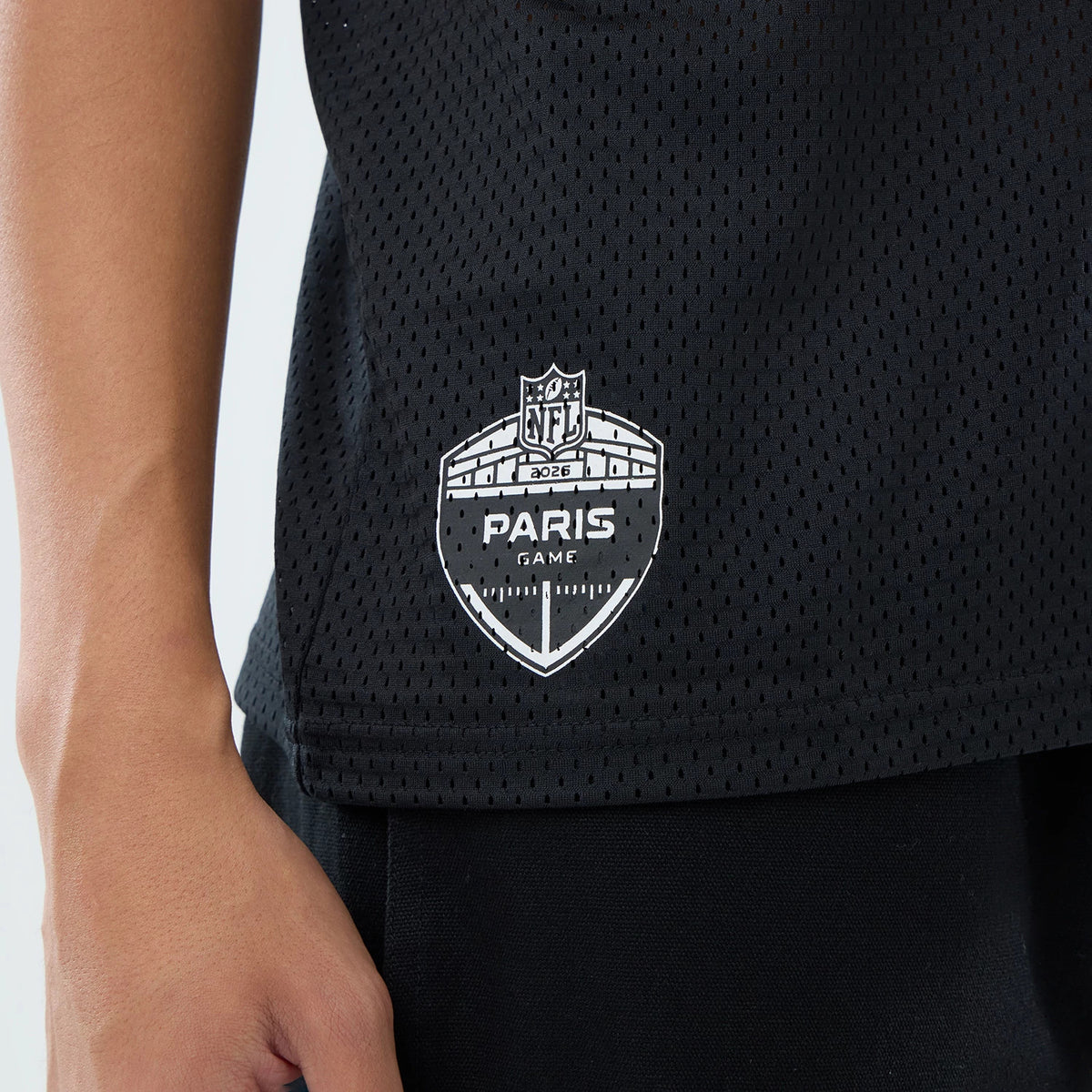 New Era Pittsburgh Steelers NFL International Games 2026 Black Mesh Jersey, close-up view showing the detailed white Paris Game 2026 graphic on the lower side of the black mesh fabric, with a model wearing black trousers.