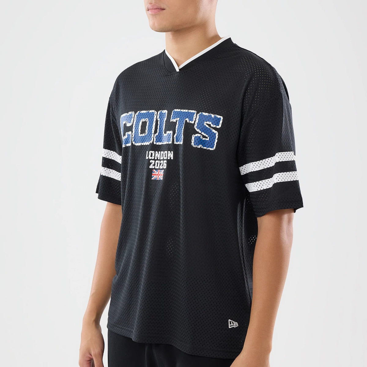 New Era Indianapolis Colts NFL International Games 2026 Black Mesh Jersey, three-quarter view on a model displaying blue Colts lettering across the chest, a London 2026 graphic beneath, and dual white-striped sleeves over a mesh fabric.