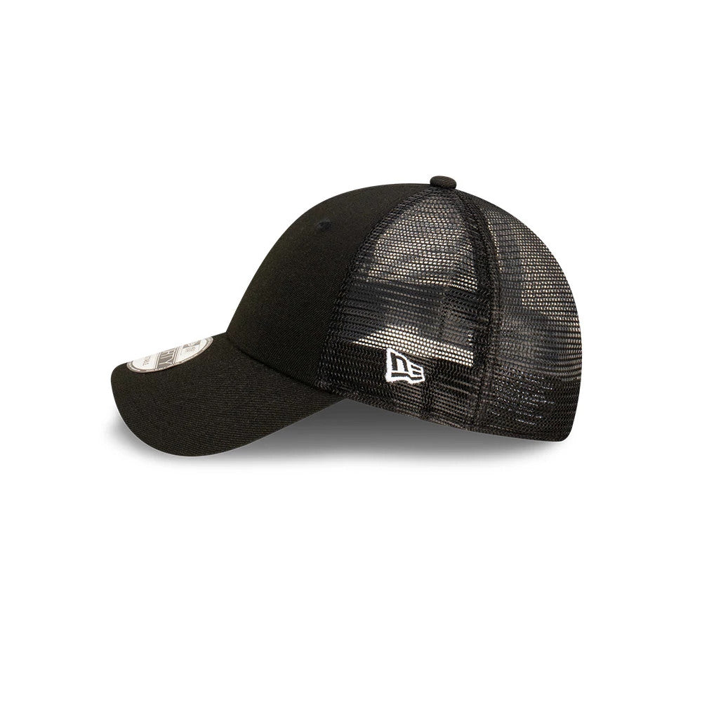 New Era Blank Black 9FORTY Trucker Cap, side view showing the white embroidered New Era flag logo on the black mesh rear panels, with a curved visor and a 9FORTY size sticker on the black front panels.