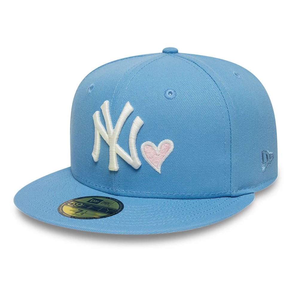 New York Yankees MLB Heart Pastel Blue New Era 59FIFTY Fitted Cap, three-quarter view showing the white embroidered NY logo with a pink heart on the front panel, blue flat visor with a gold 59FIFTY size sticker.