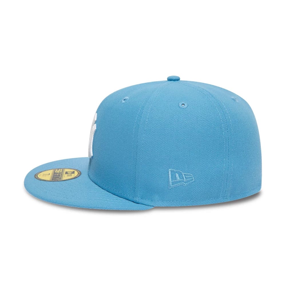 New York Yankees Pastel Blue New Era 59FIFTY Fitted Cap, side view showing the light blue embroidered New Era flag logo on the left side of the structured pastel blue crown, contrasting with a gold 59FIFTY size sticker on the flat visor.
