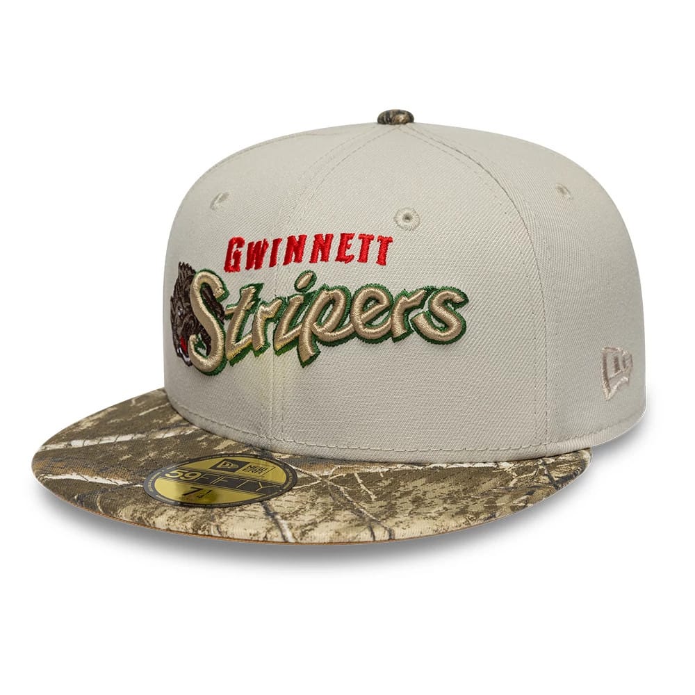 Gwinnett Stripers MiLB Hometown Sidepatch Beige New Era 59FIFTY Fitted Cap, front three-quarter view showing the red and green embroidered Gwinnett Stripers logo on a structured beige crown, with a camouflage visor and gold 59FIFTY size sticker.