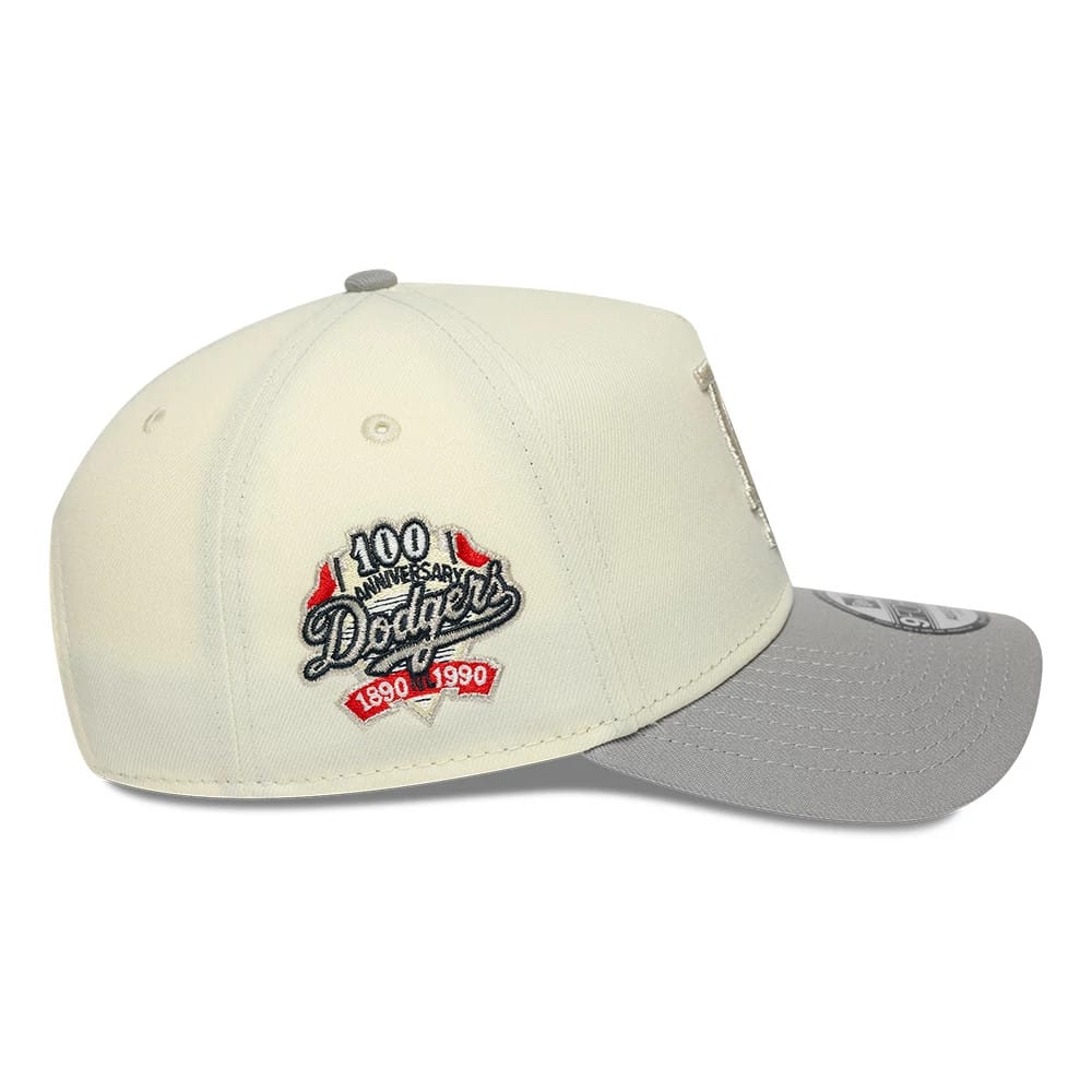 LA Dodgers MLB Cooperstown White & Grey New Era 9FORTY A-Frame Cap, side view showing the 100th anniversary Dodgers logo embroidered on the white crown, grey curved visor with a 9FORTY size sticker, and matching top button.