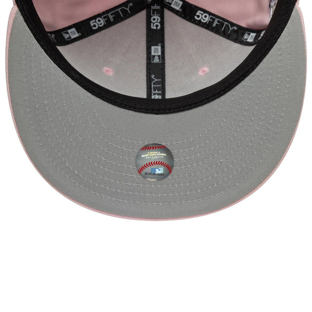 New York Yankees MLB World Series Pink New Era 59FIFTY Fitted Cap, inside view showing a grey undervisor with a baseball-themed sticker, black 59FIFTY taping with white text, and a light pink interior sweatband.