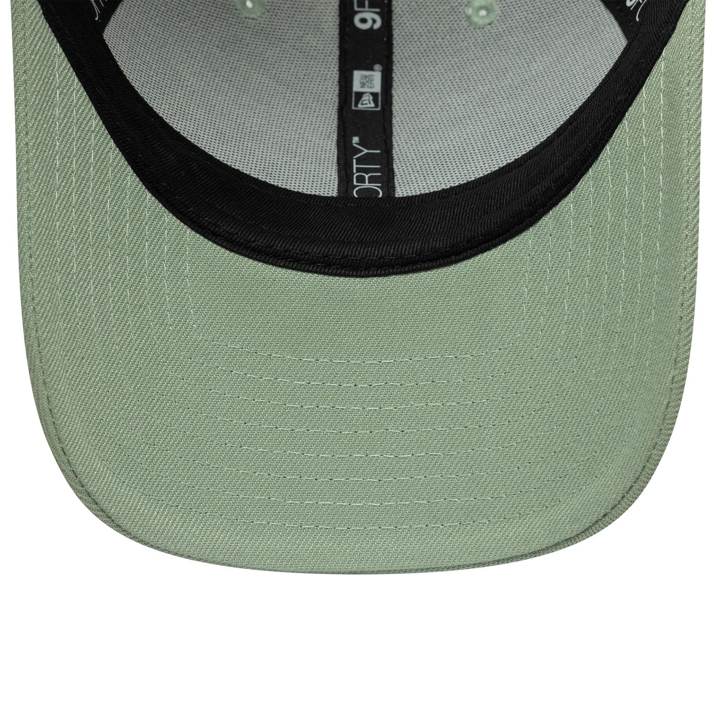 New Era Green 9FORTY Trucker Adjustable Cap, inside view showing the light green undervisor contrasted by a black sweatband, and interior taping marked with 9FORTY branding, offering an insight into the cap's structure with stitching.