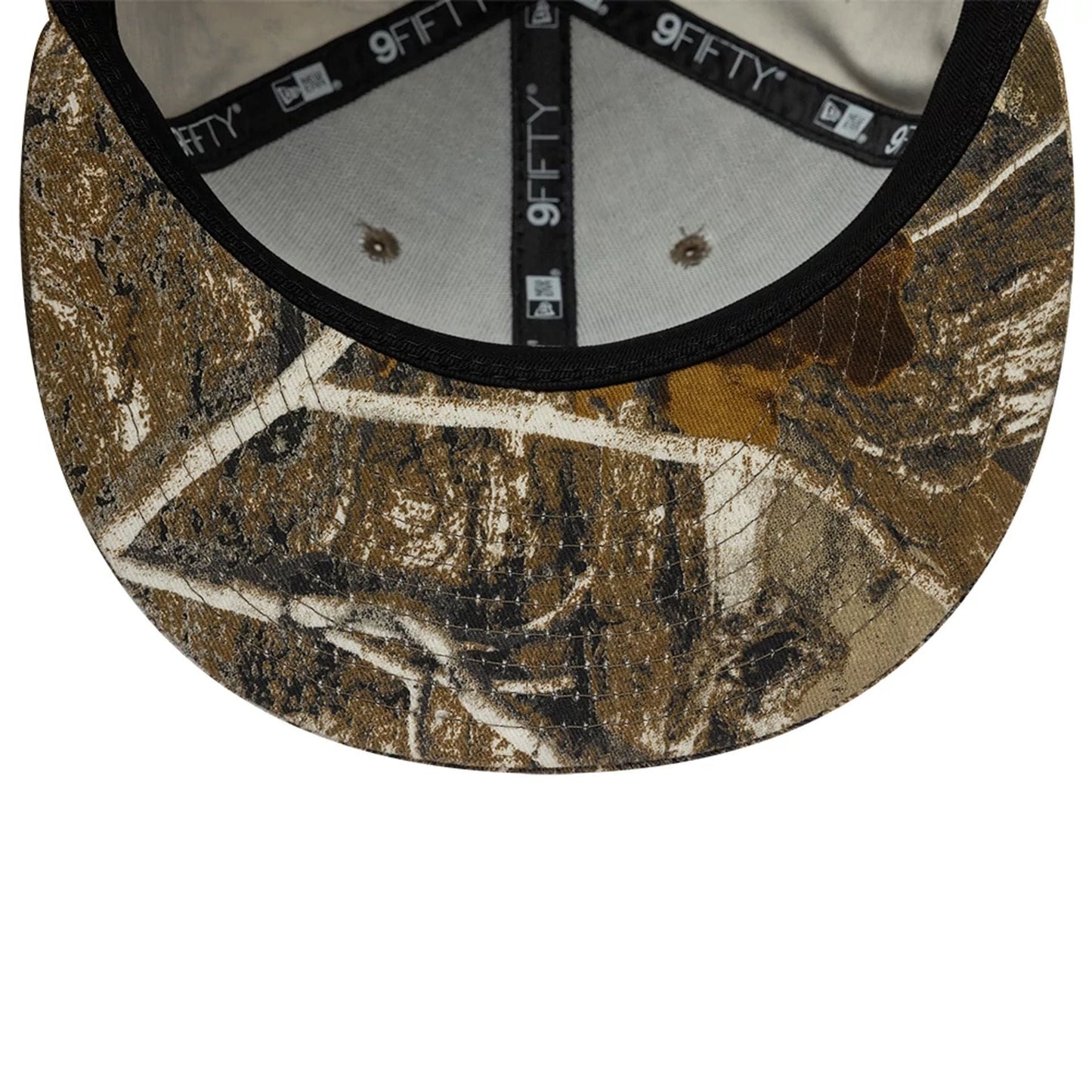 New Era Real Tree Beige 9FIFTY Snapback Cap, inside view showing the brown camo-printed visor with a black edge, white 9FIFTY taping around the cream internal crown, and grey sweatband with brown eyelets.