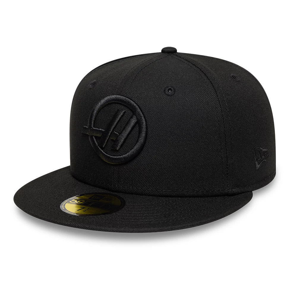TGR Haas F1 Black New Era 59FIFTY Fitted Cap, front view showing a raised black embroidered Haas F1 logo on the front panel, a black visor with a gold 59FIFTY size sticker, and the New Era flag logo on the left side.
