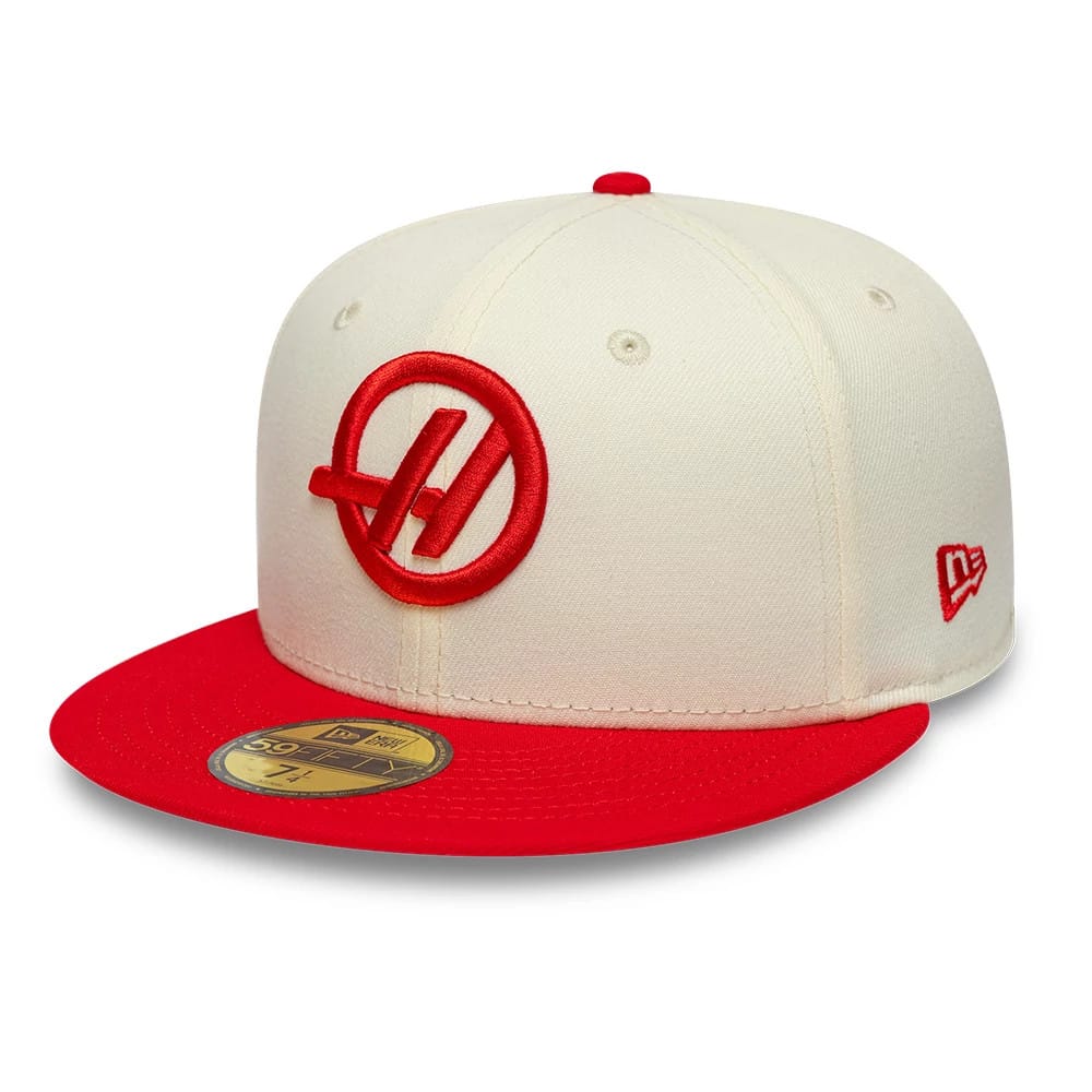 TGR Haas F1 Cream & Red New Era 59FIFTY Fitted Cap, three-quarter view showing a red embroidered Haas logo on the front panel, a gold 59FIFTY size sticker on the red flat visor, and red New Era flag logo on the left side.