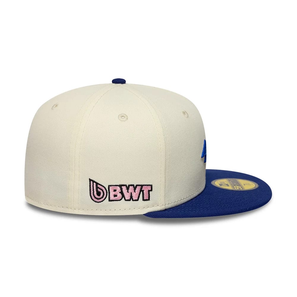 Alpine Racing Cream & Blue New Era 59FIFTY Fitted Cap, side view showing the pink and black embroidered BWT logo on the cream-coloured structured crown, paired with a blue flat visor featuring a gold 59FIFTY size sticker.