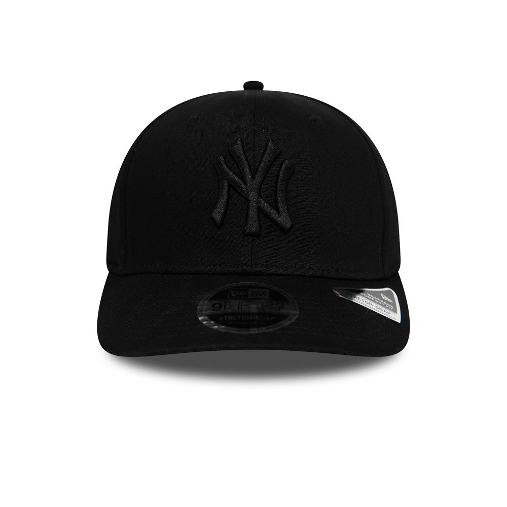 New York Yankees Tonal Black New Era 9FIFTY Stretch Snap Cap, front view showing the raised black NY logo embroidered on the front panel, with a black curved visor and the 9FIFTY size sticker on top.